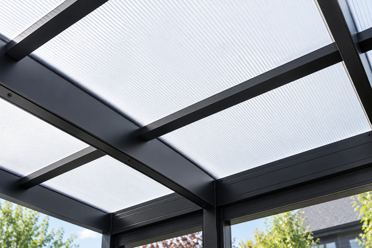 Underside of a patio cover with translucent ribbed panels supported by a dark metal frame.